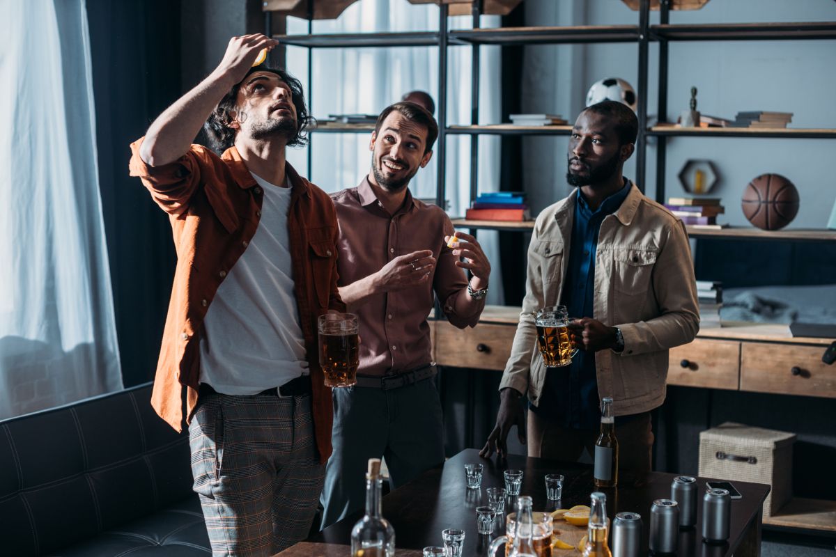 young multiethnic male friends drinking beer and partying together