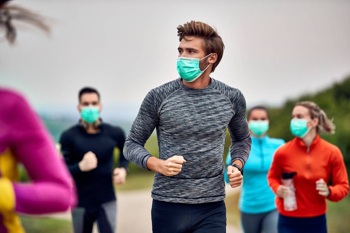Male runner wearing face mask while participating in marathon during virus epidemic.