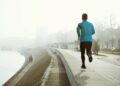 Runner exercising and jogging outdoor in fog and misty weather to stay active