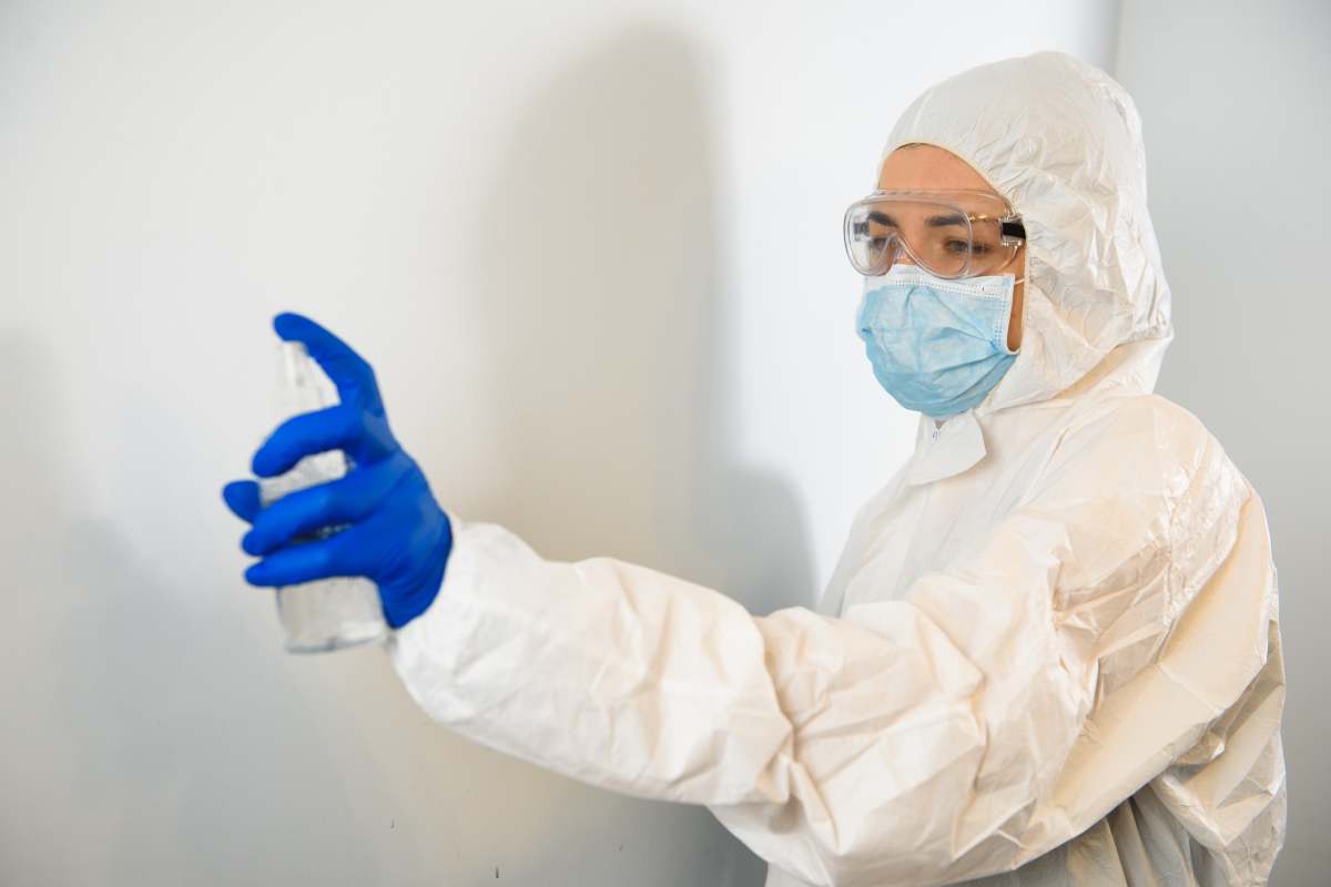 a doctor in a protective suit disinfects with an antiseptic. Coronavirus control concept. Quarantine.