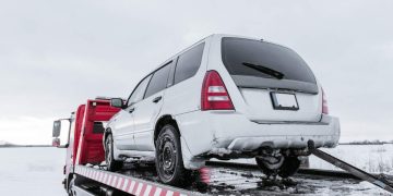 Car on tow truck on snow road