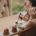 Crop photo of woman eating double tiramisu dessert decorated with fresh berries at the cafe